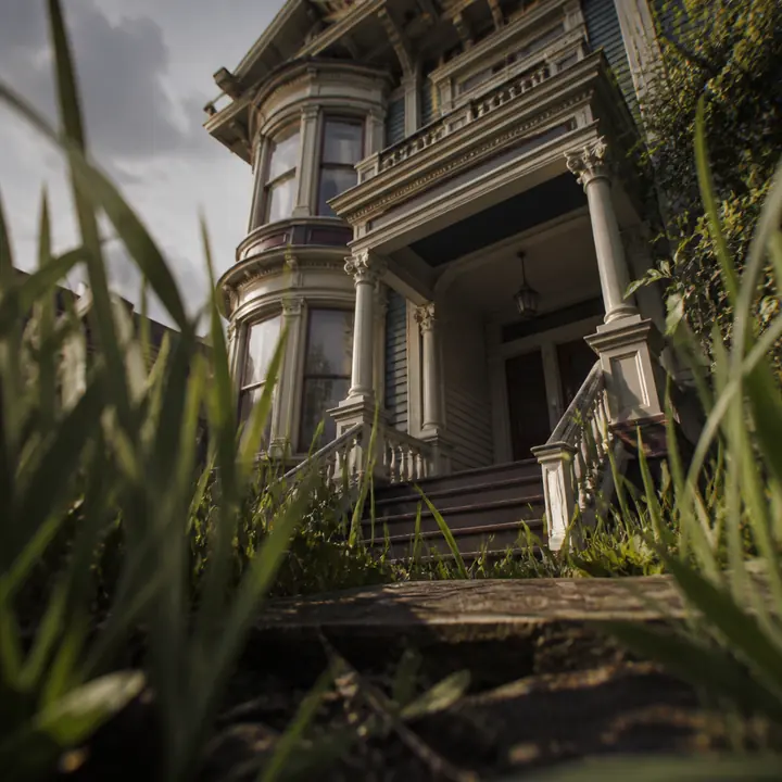 Giant grass blades before a Victorian porch